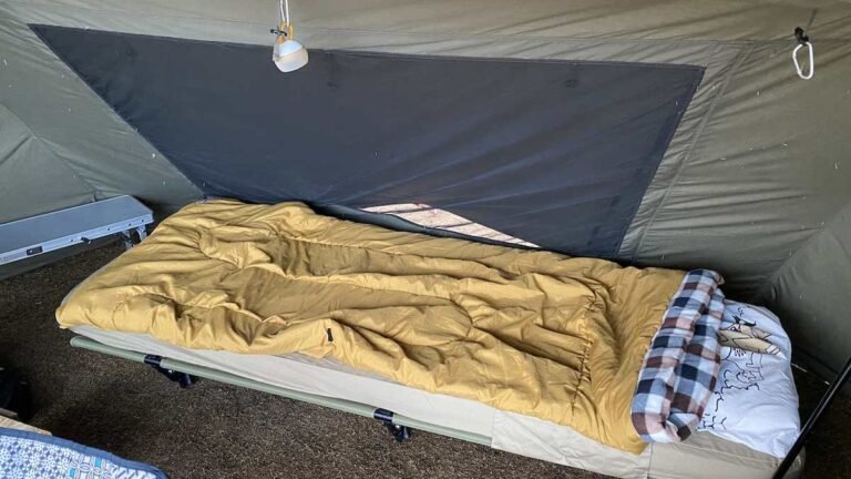 Camp stretcher bed set up inside a tent
